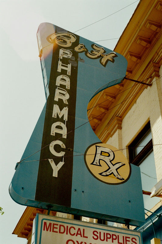 A retro pharmacy sign announces business.